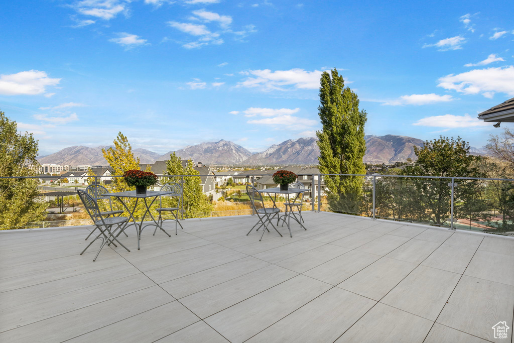 View of patio featuring outdoor dining area, a mountain view, and a residential view