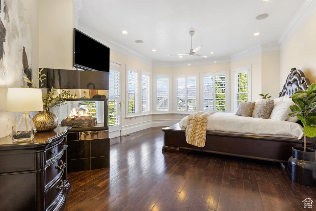 Bedroom featuring dark wood-type flooring, recessed lighting, crown molding, and baseboards