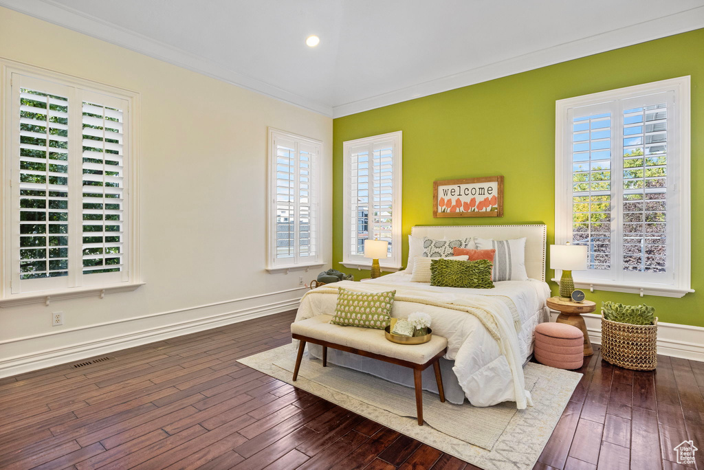Bedroom featuring ornamental molding, multiple windows, hardwood / wood-style flooring, baseboards, and recessed lighting
