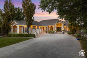 Single story home featuring a garage, driveway, and a front lawn