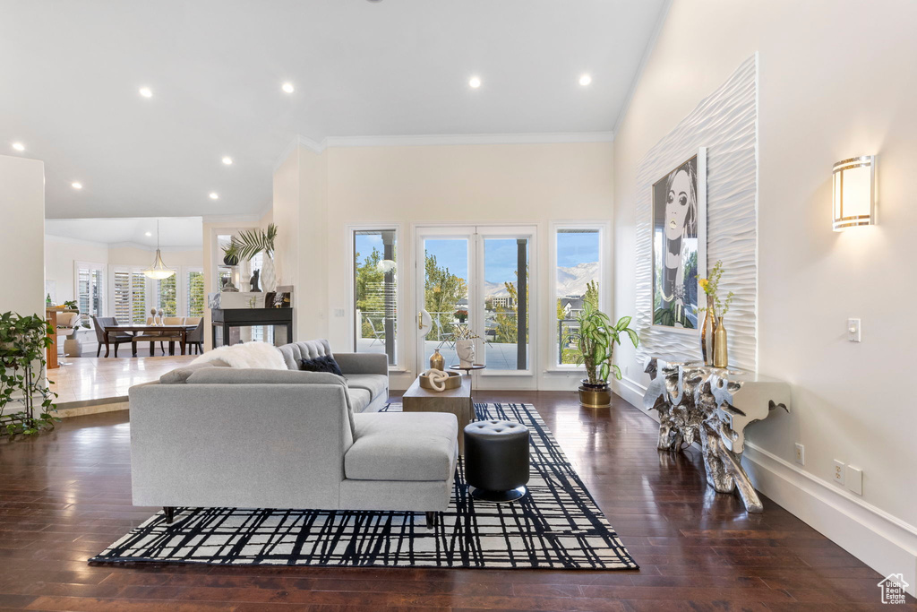 Living room with crown molding, wood finished floors, baseboards, and recessed lighting