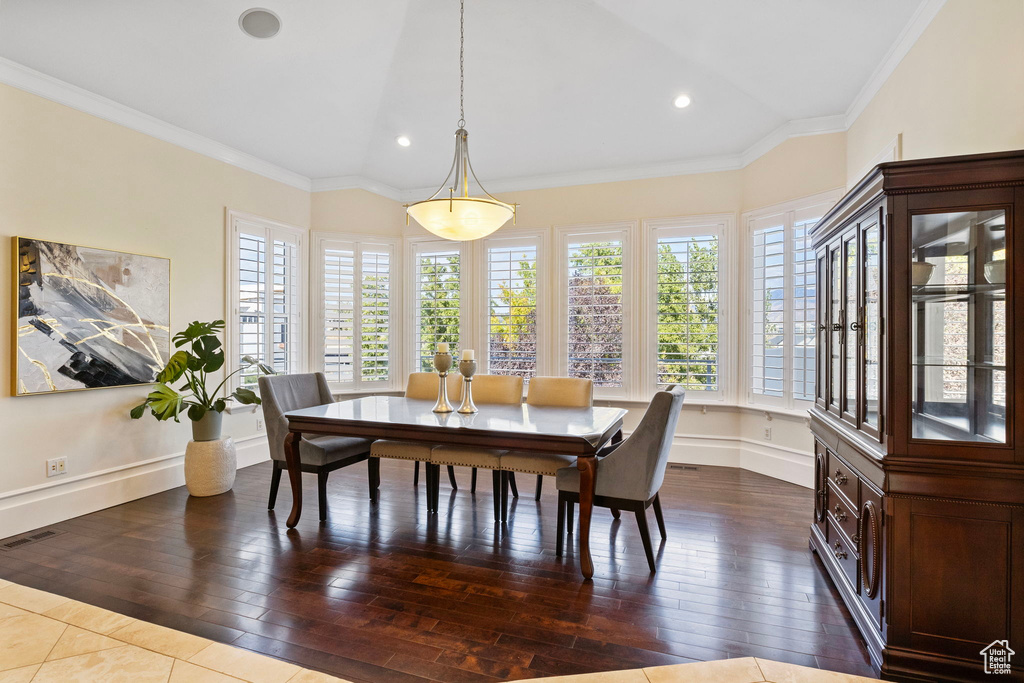 Dining room featuring plenty of natural light, dark wood finished floors, ornamental molding, baseboards, and recessed lighting