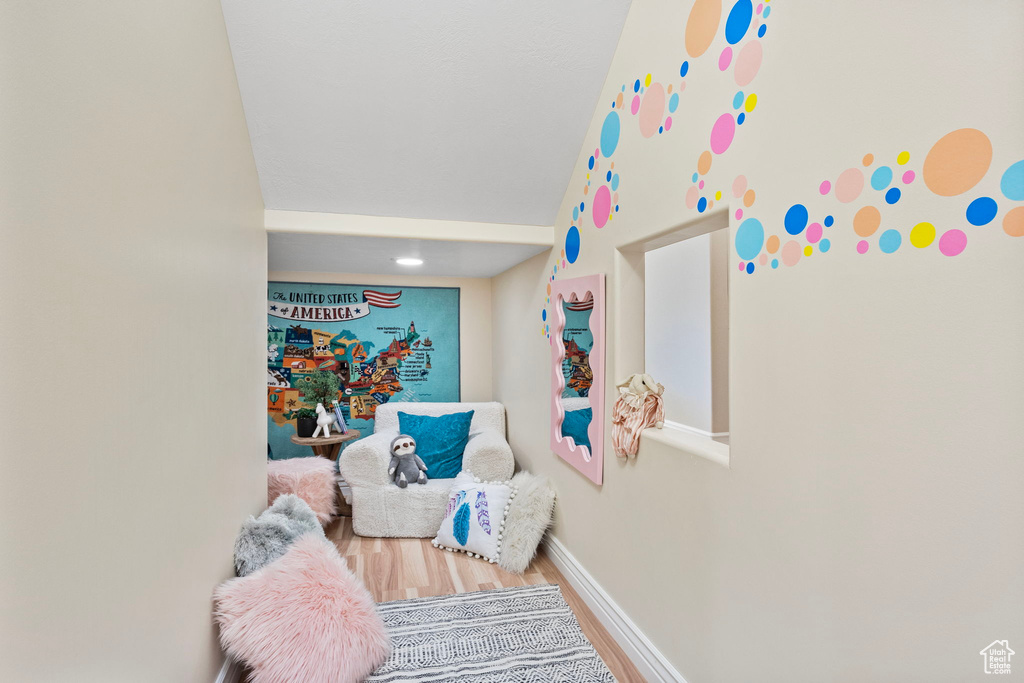 Game room with wood finished floors, baseboards, and vaulted ceiling