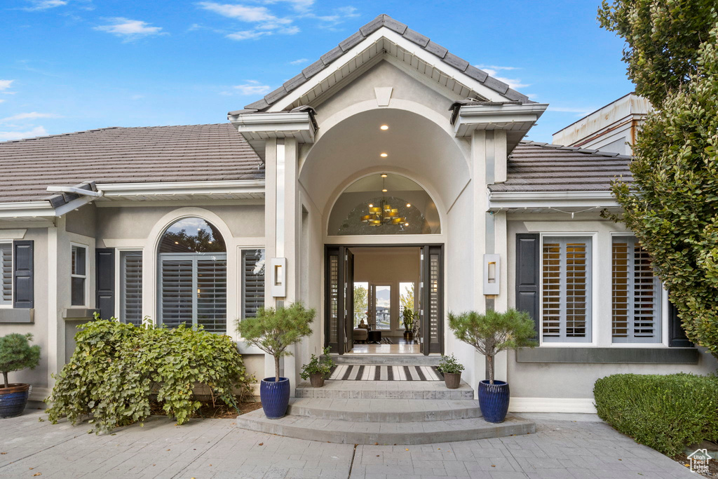 Doorway to property featuring a tiled roof and stucco siding