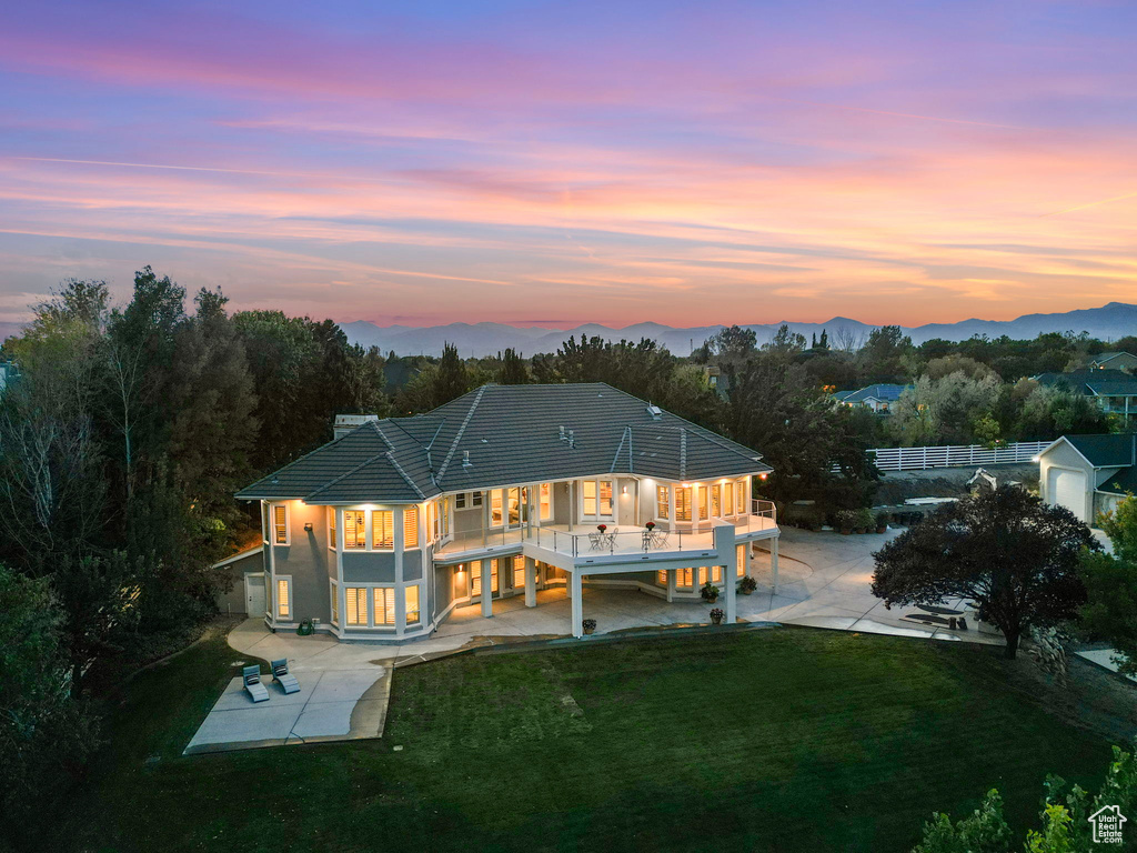 Rear view of house featuring a patio, a lawn, a carport, and driveway