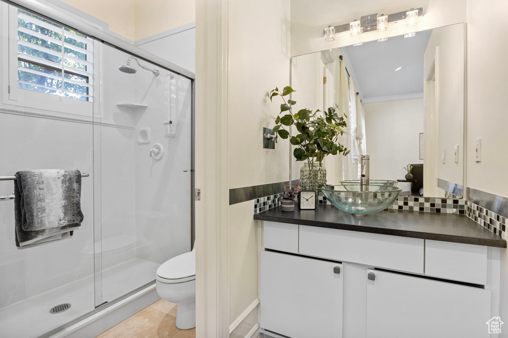 Full bath with toilet, a stall shower, crown molding, and vanity