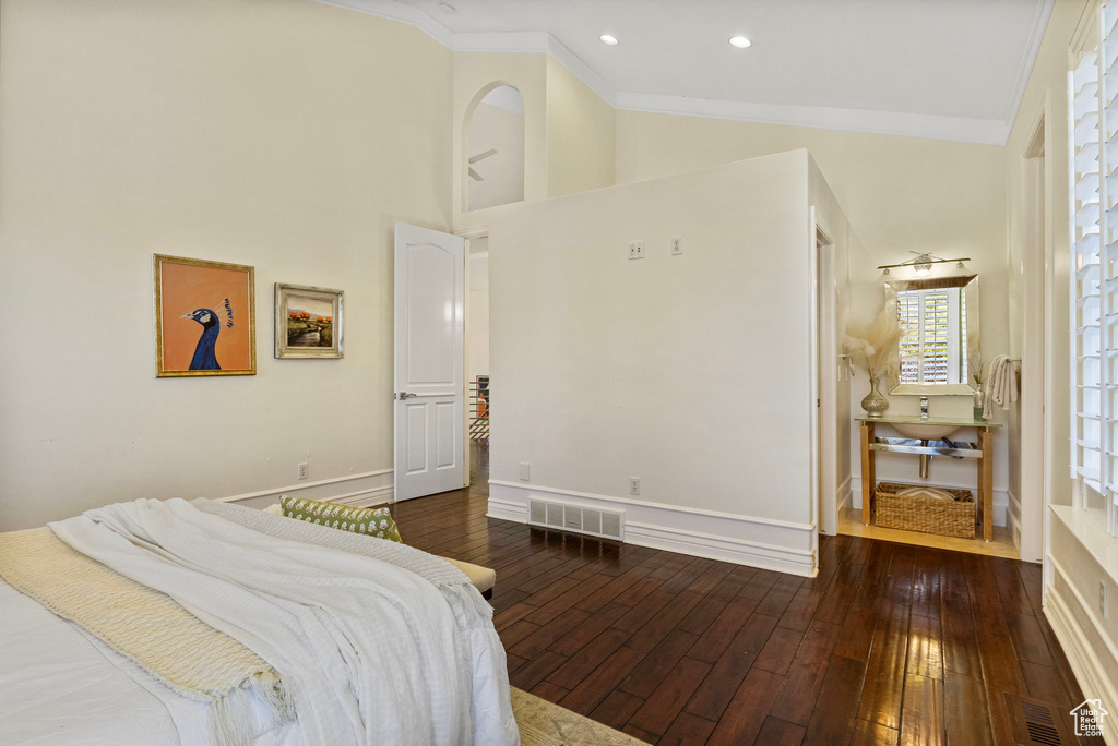 Bedroom with crown molding, wood-type flooring, baseboards, recessed lighting, and a towering ceiling