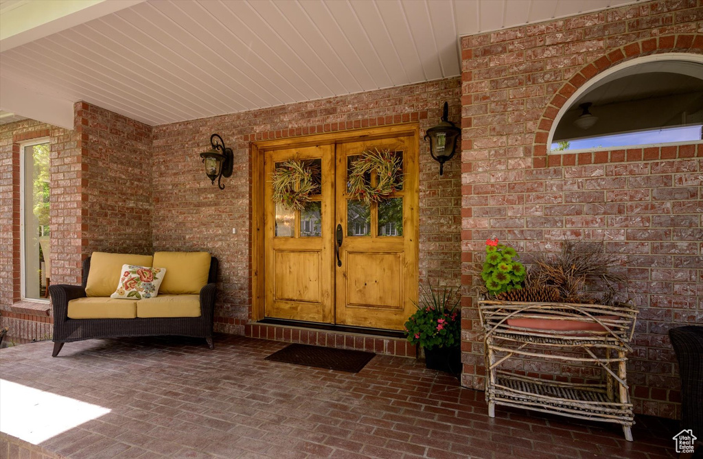 Property entrance featuring brick siding and covered porch