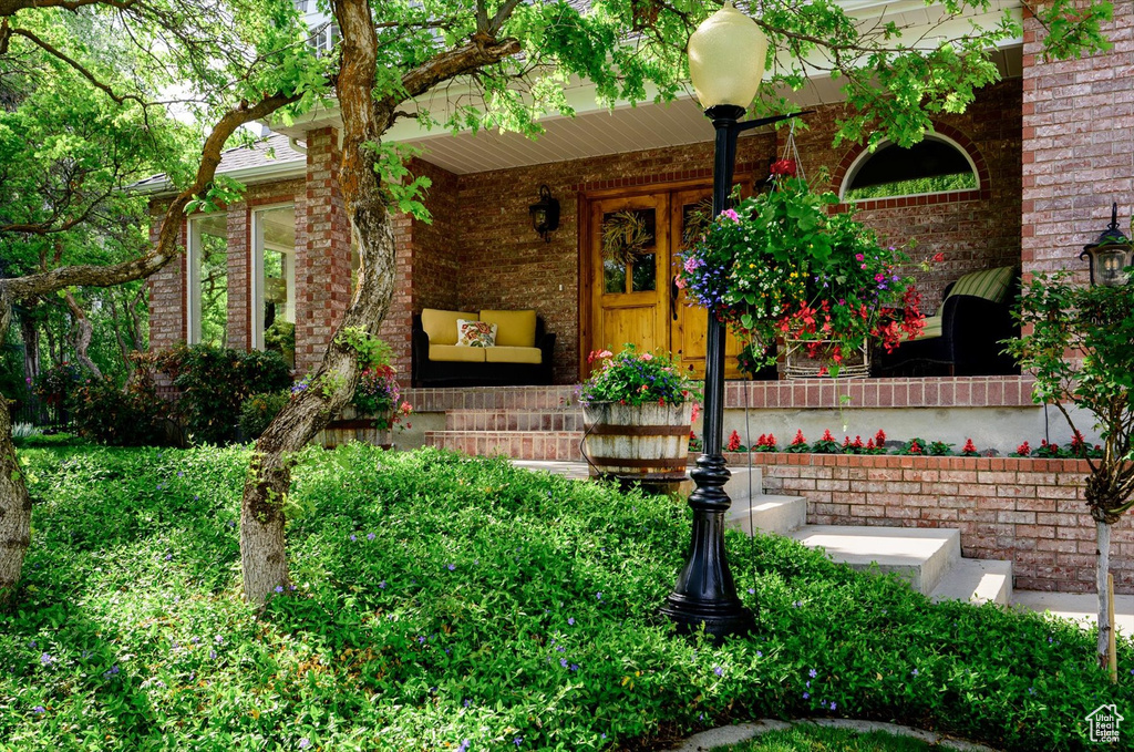 Doorway to property with a porch and brick siding