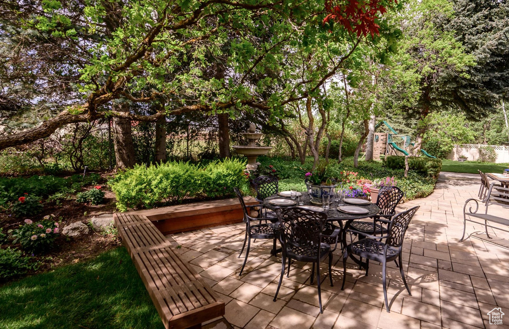 View of patio / terrace with a playground, outdoor dining space, and fence