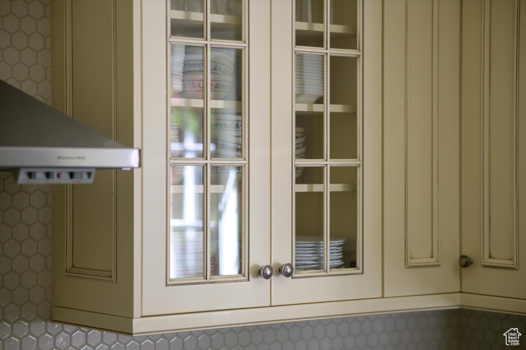 Kitchen view of french doors, cream cabinetry, and board and batten siding