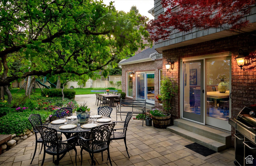 View of patio / terrace with outdoor dining space, fence, entry steps, and grilling area