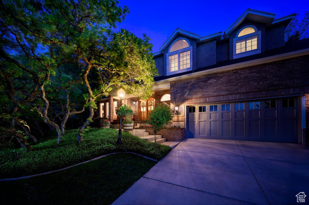 View of front of house with an attached garage, brick siding, and concrete driveway
