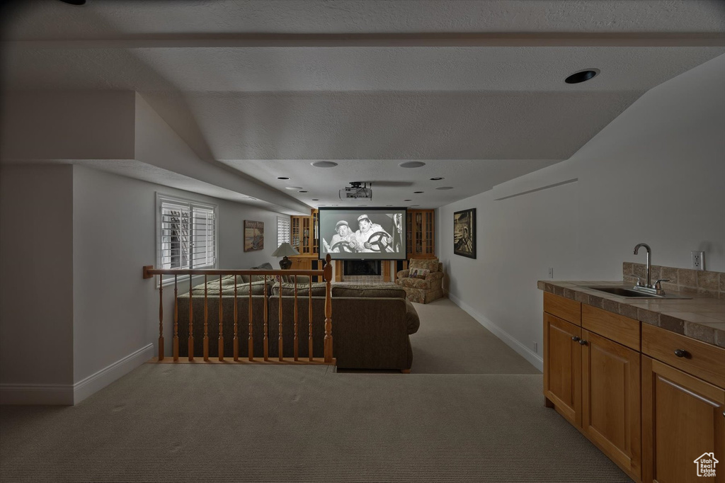 Living area with light carpet, baseboards, and wet bar