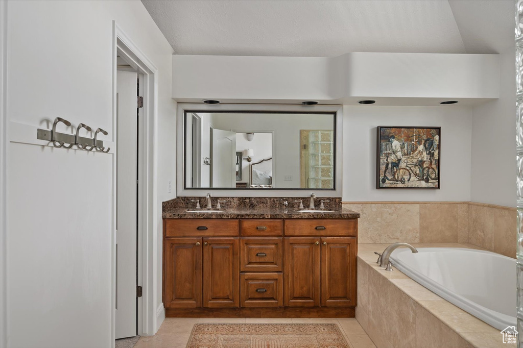 Full bath featuring a bath, tile patterned floors, and double vanity