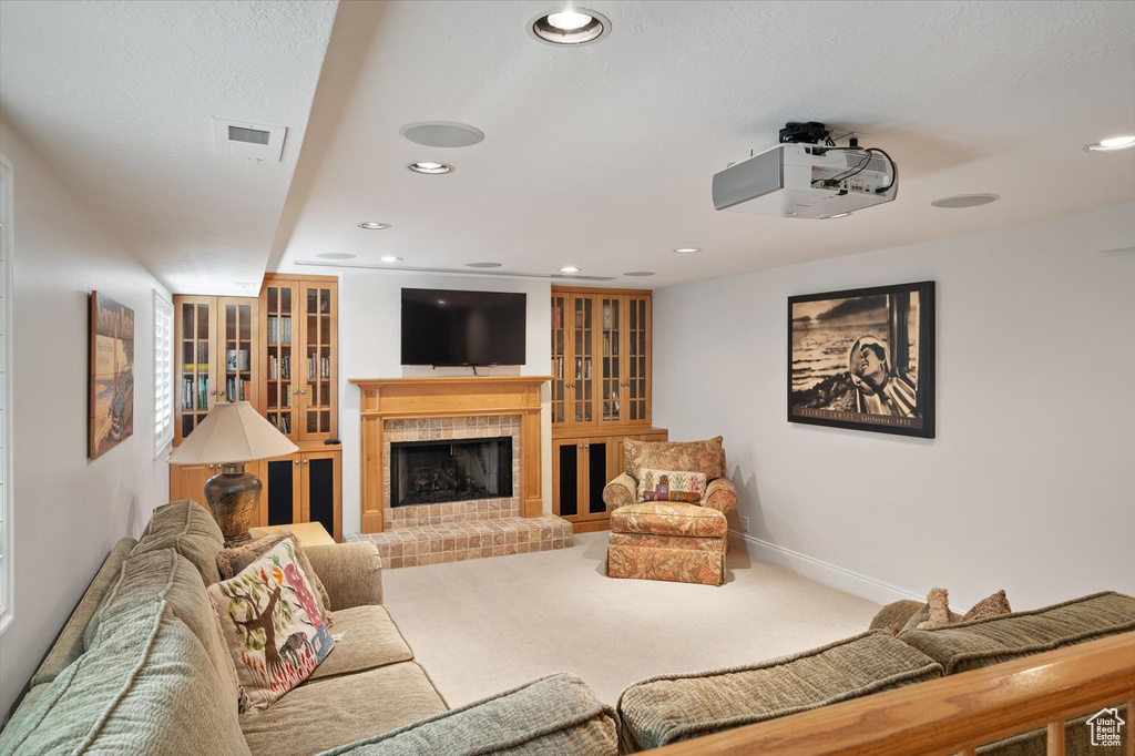 Carpeted living area with recessed lighting, a fireplace, and baseboards