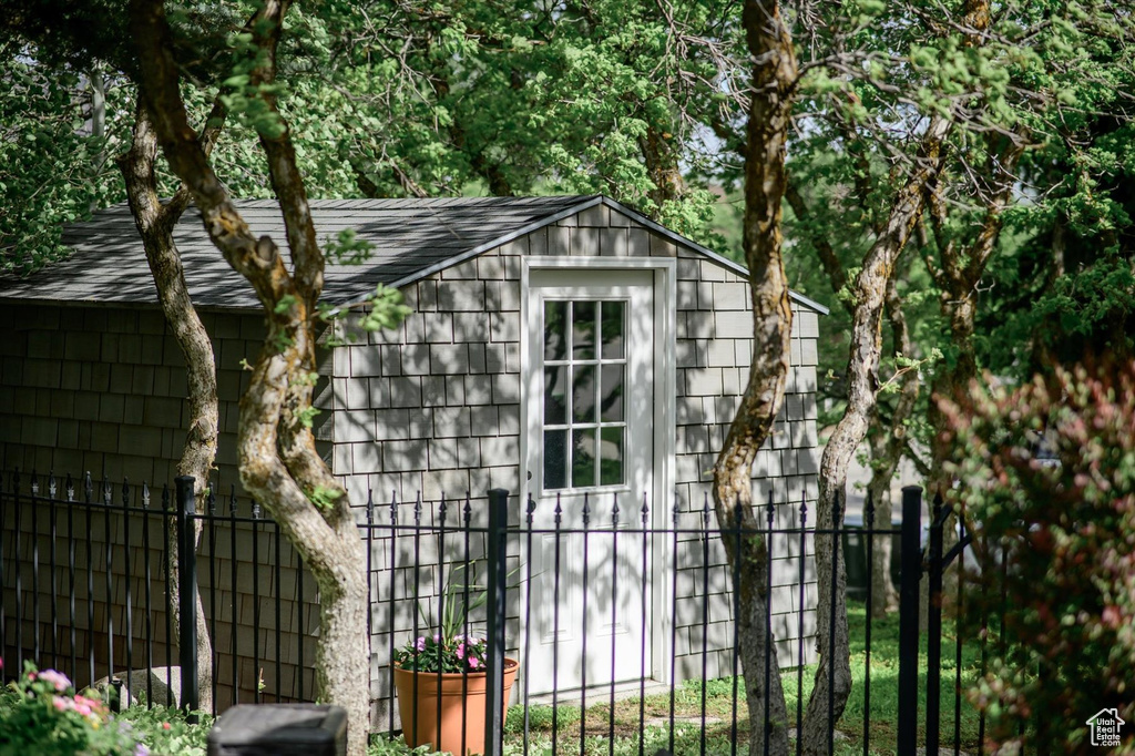 View of outbuilding featuring fence and an outbuilding