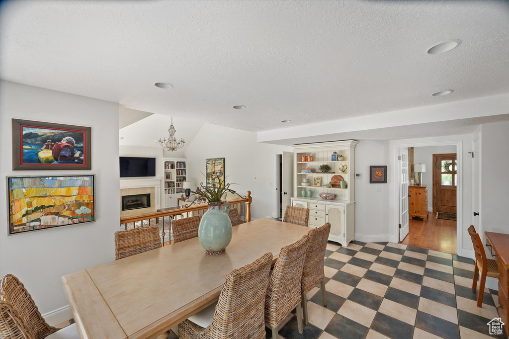 Dining room with light floors, a chandelier, baseboards, recessed lighting, and a textured ceiling