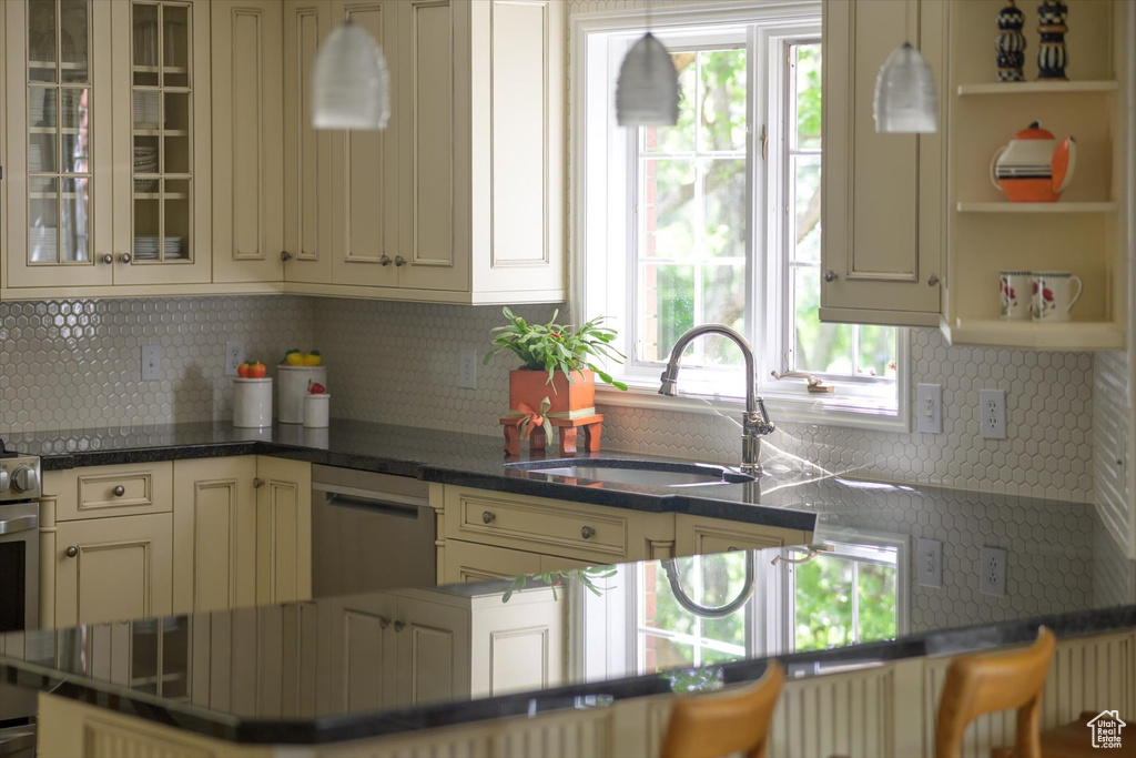 Kitchen with a sink, stainless steel dishwasher, healthy amount of natural light, and decorative backsplash