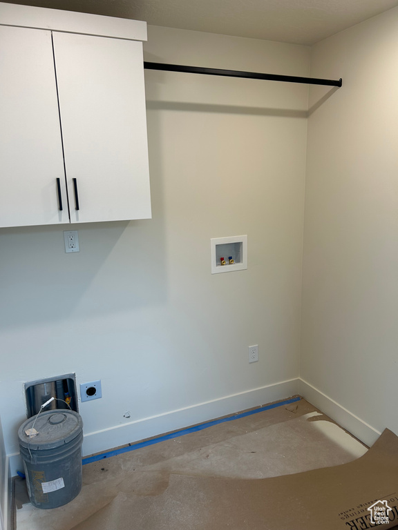 Clothes washing area with cabinet space, baseboards, hookup for an electric dryer, washer hookup, and gas dryer hookup