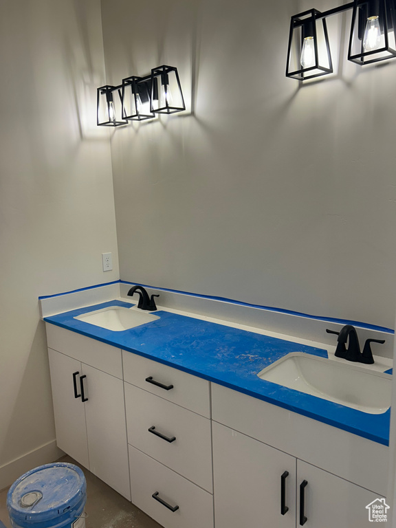 Bathroom with double vanity and baseboards