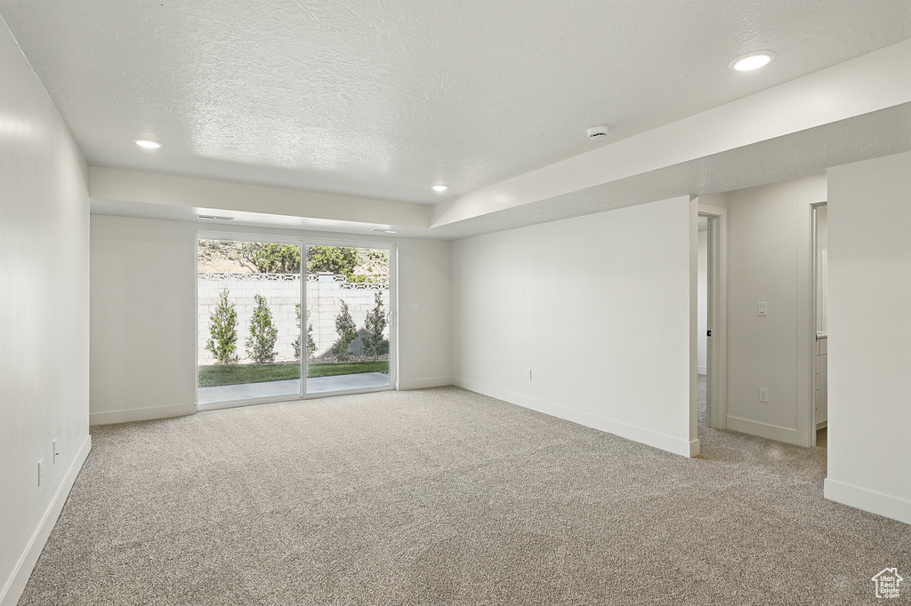 Empty room with carpet flooring, baseboards, recessed lighting, and a textured ceiling