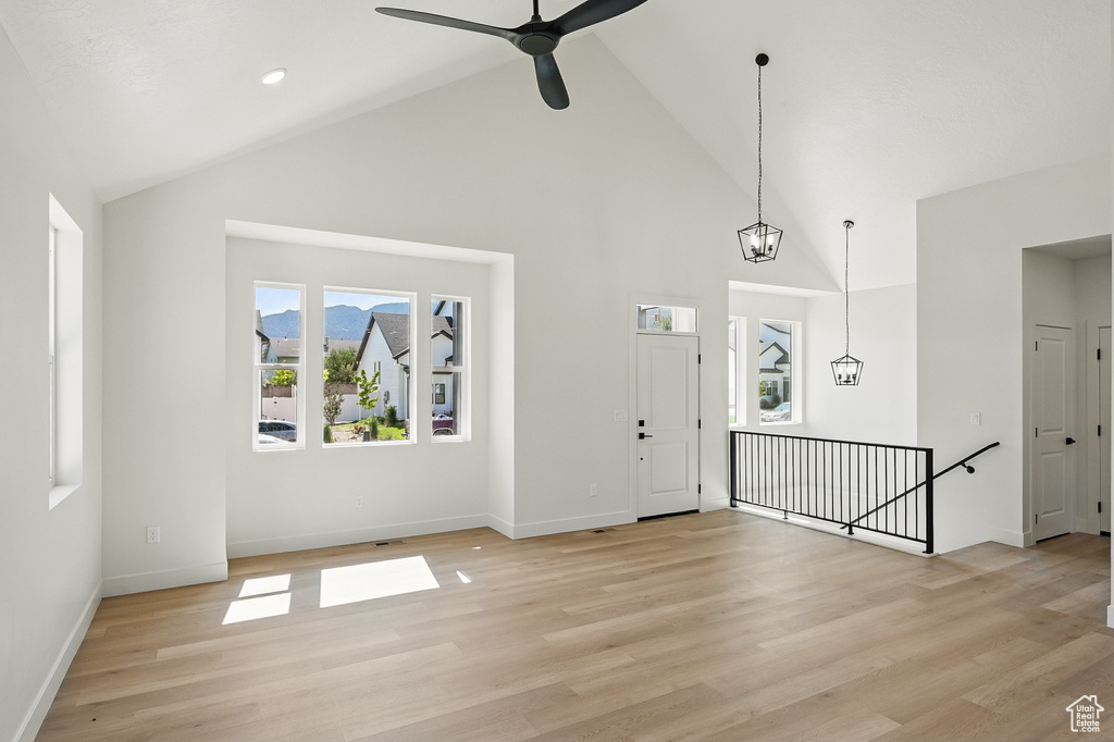 Entryway featuring high vaulted ceiling, light wood-style floors, baseboards, and ceiling fan