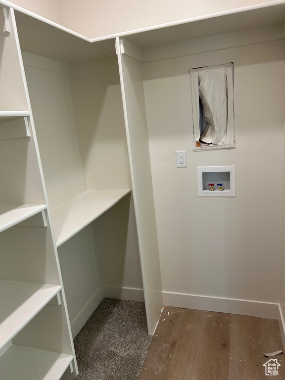 Clothes washing area with washer hookup, wood finished floors, and baseboards