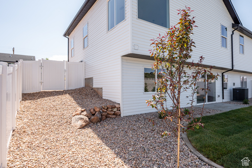 View of home\'s exterior featuring cooling unit and a gate