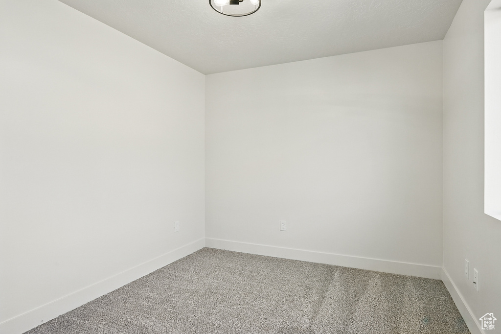 Carpeted empty room featuring baseboards