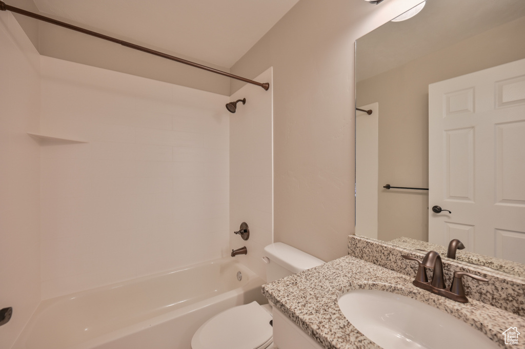 Bathroom featuring toilet, tub / shower combination, and vanity