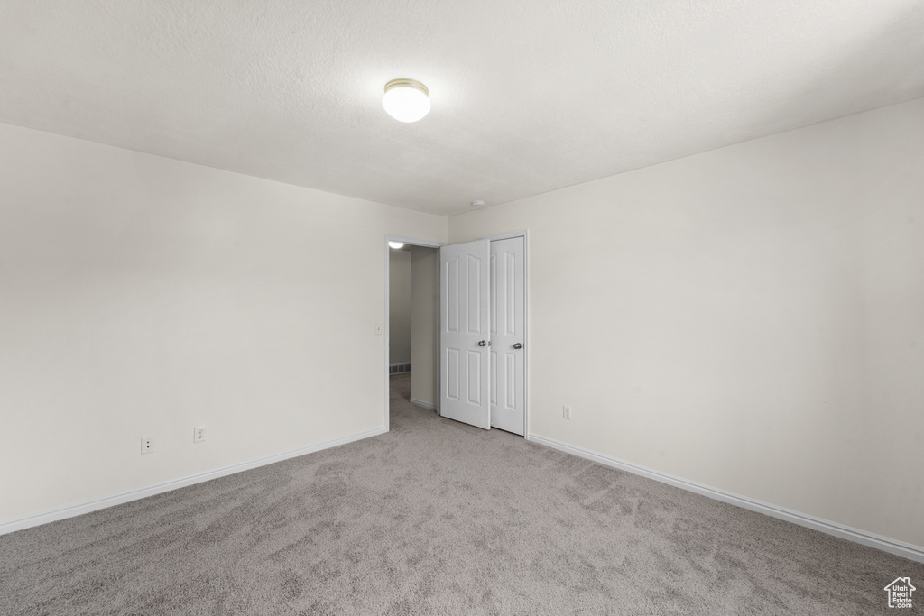 Unfurnished room featuring carpet and baseboards