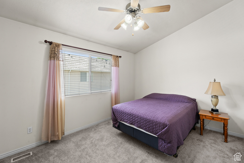 Bedroom featuring carpet flooring, baseboards, vaulted ceiling, and a ceiling fan