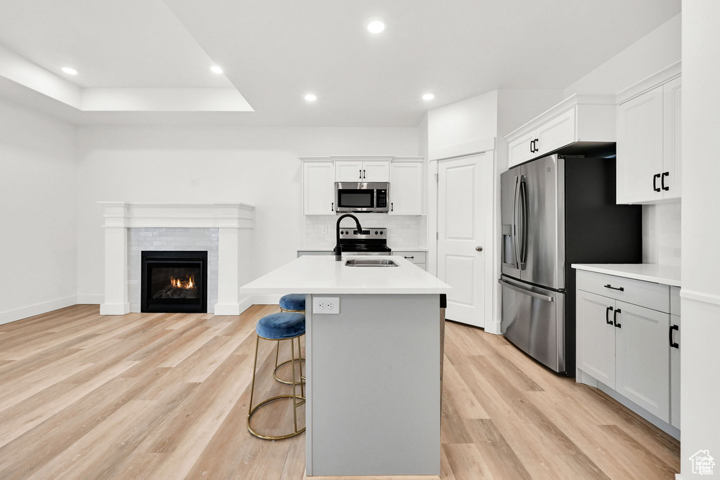 Kitchen with appliances with stainless steel finishes, light countertops, light wood finished floors, and recessed lighting