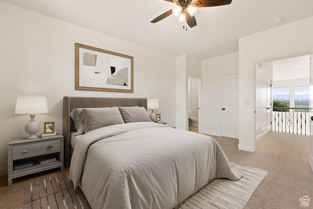 Carpeted bedroom featuring ensuite bath, baseboards, and a ceiling fan