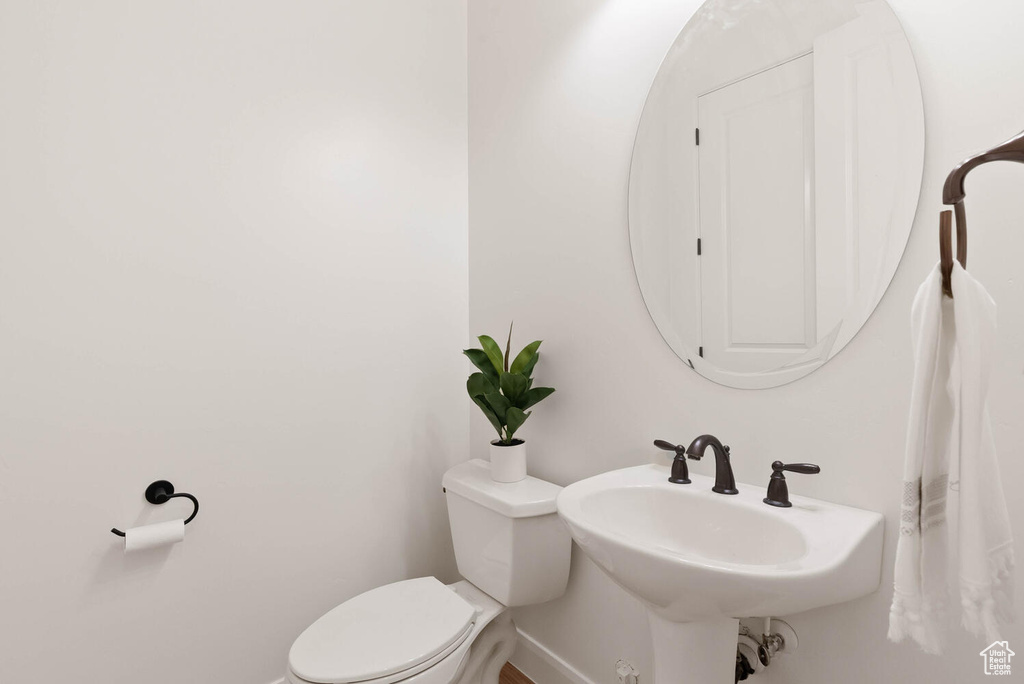 Bathroom with toilet, baseboards, and a sink