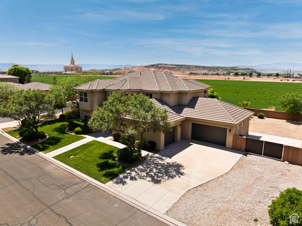 View of front of home with a garage, concrete driveway, stucco siding, a gate, and a tiled roof