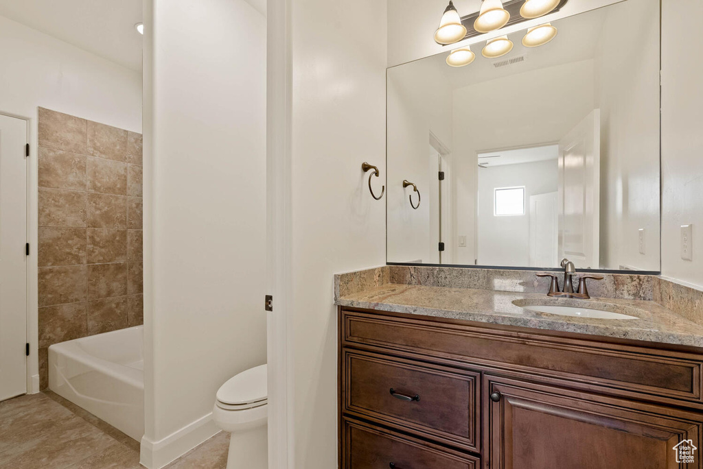 Bathroom with toilet, vanity, tile patterned floors, and baseboards