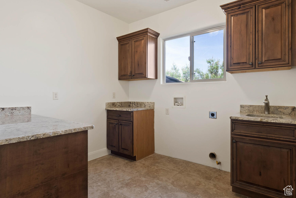 Washroom with hookup for a washing machine, electric dryer hookup, gas dryer hookup, and cabinet space