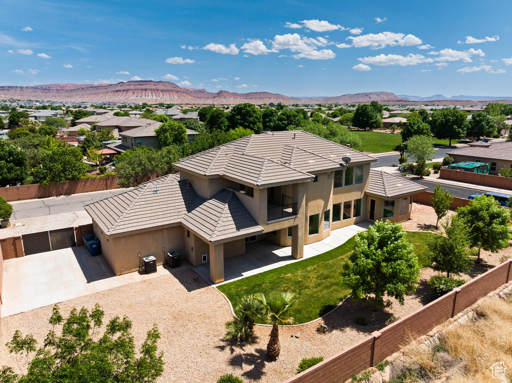 Aerial view of property and surrounding area with a mountain backdrop