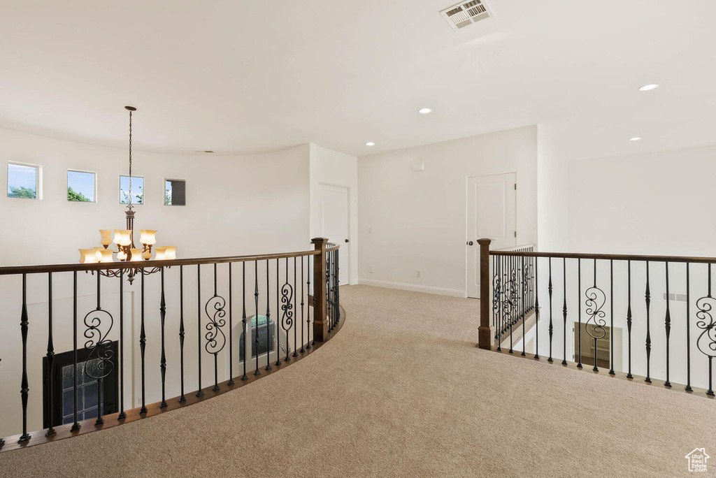 Hallway featuring a chandelier, carpet flooring, recessed lighting, baseboards, and an upstairs landing