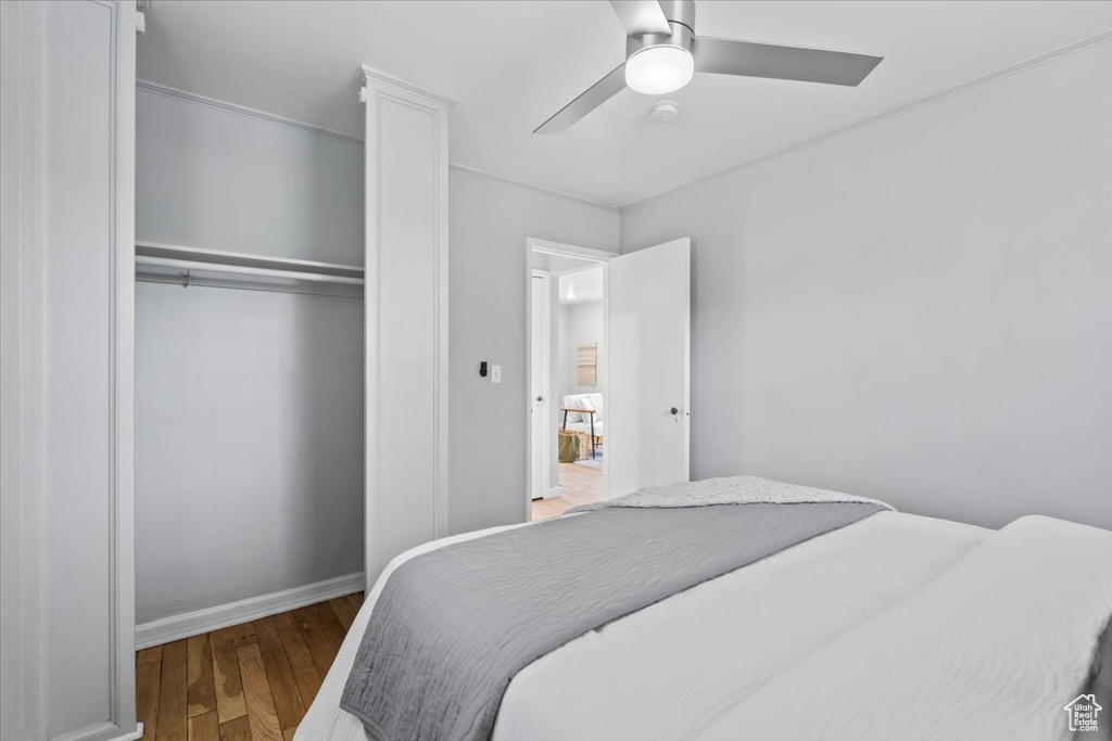 Bedroom featuring wood finished floors, a closet, a ceiling fan, and baseboards