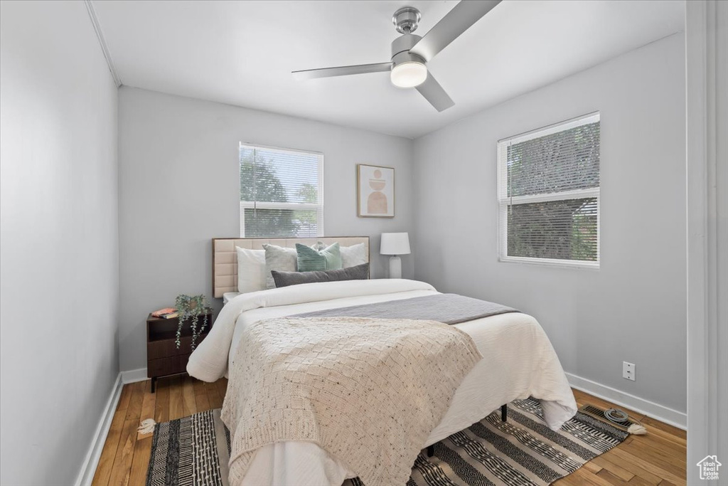 Bedroom featuring baseboards, wood finished floors, and ceiling fan