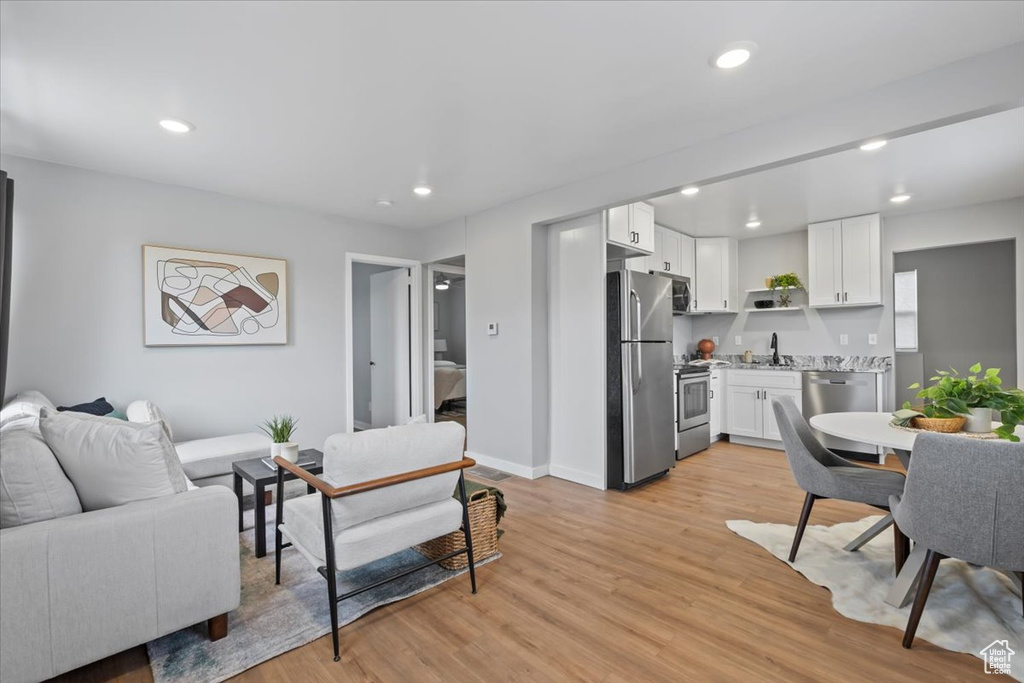 Living area with recessed lighting, light wood-style floors, and baseboards