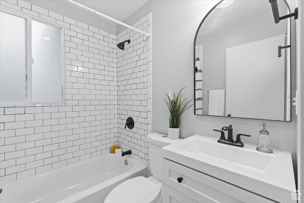 Bathroom featuring toilet, washtub / shower combination, and vanity