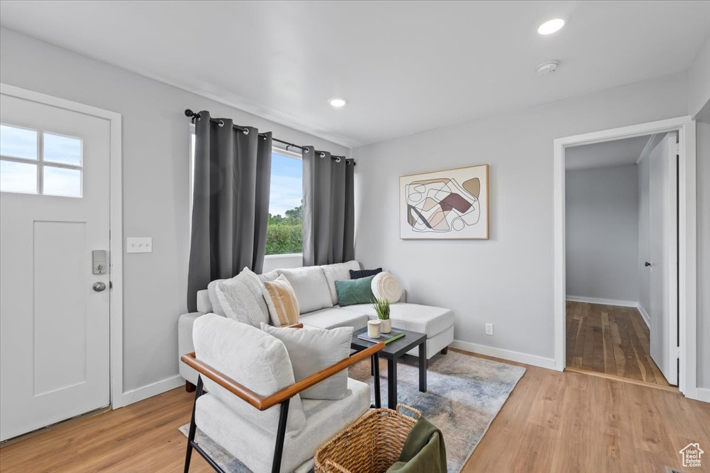 Living room featuring light wood-style floors, baseboards, and recessed lighting