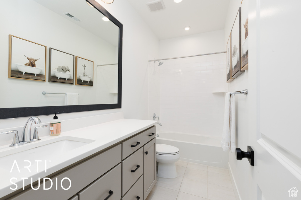 Bathroom with tile patterned floors, vanity, toilet, and visible vents