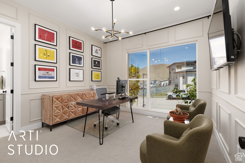 Office space featuring a notable chandelier, light carpet, visible vents, and a decorative wall