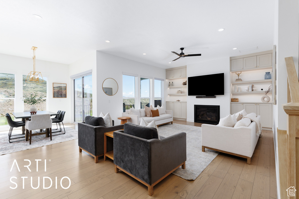 Living room with recessed lighting, a glass covered fireplace, and a healthy amount of sunlight