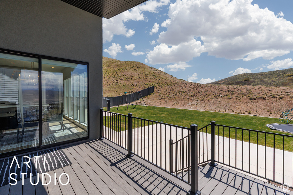 Wooden deck featuring a yard and a mountain view